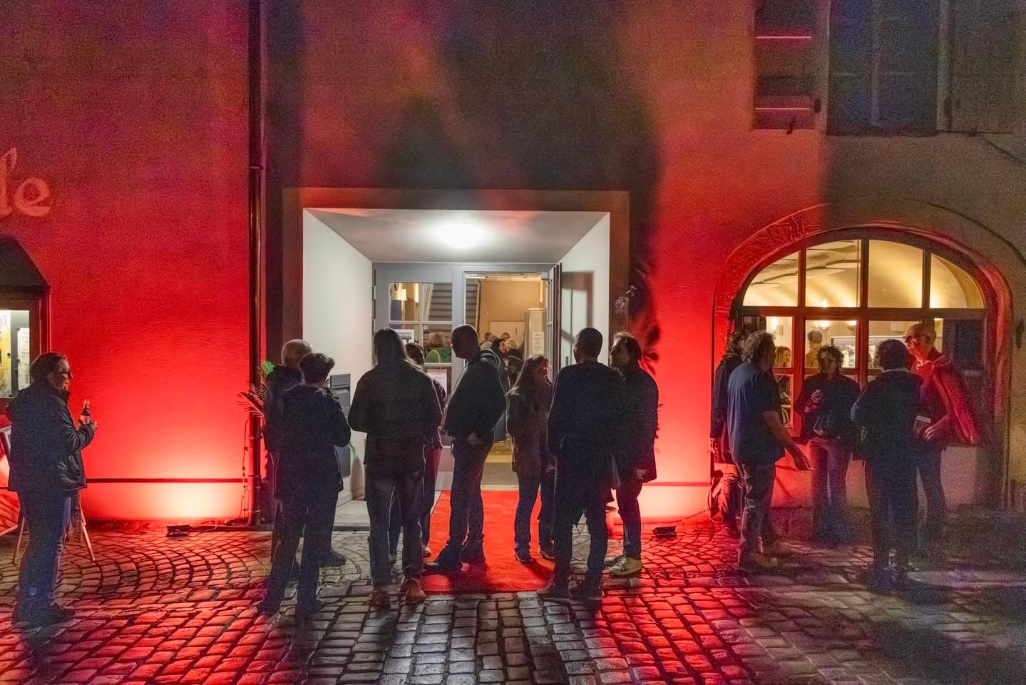 Festivalabend vor dem KulturKino Feuchtwangen, rot angestrahlter Eingang